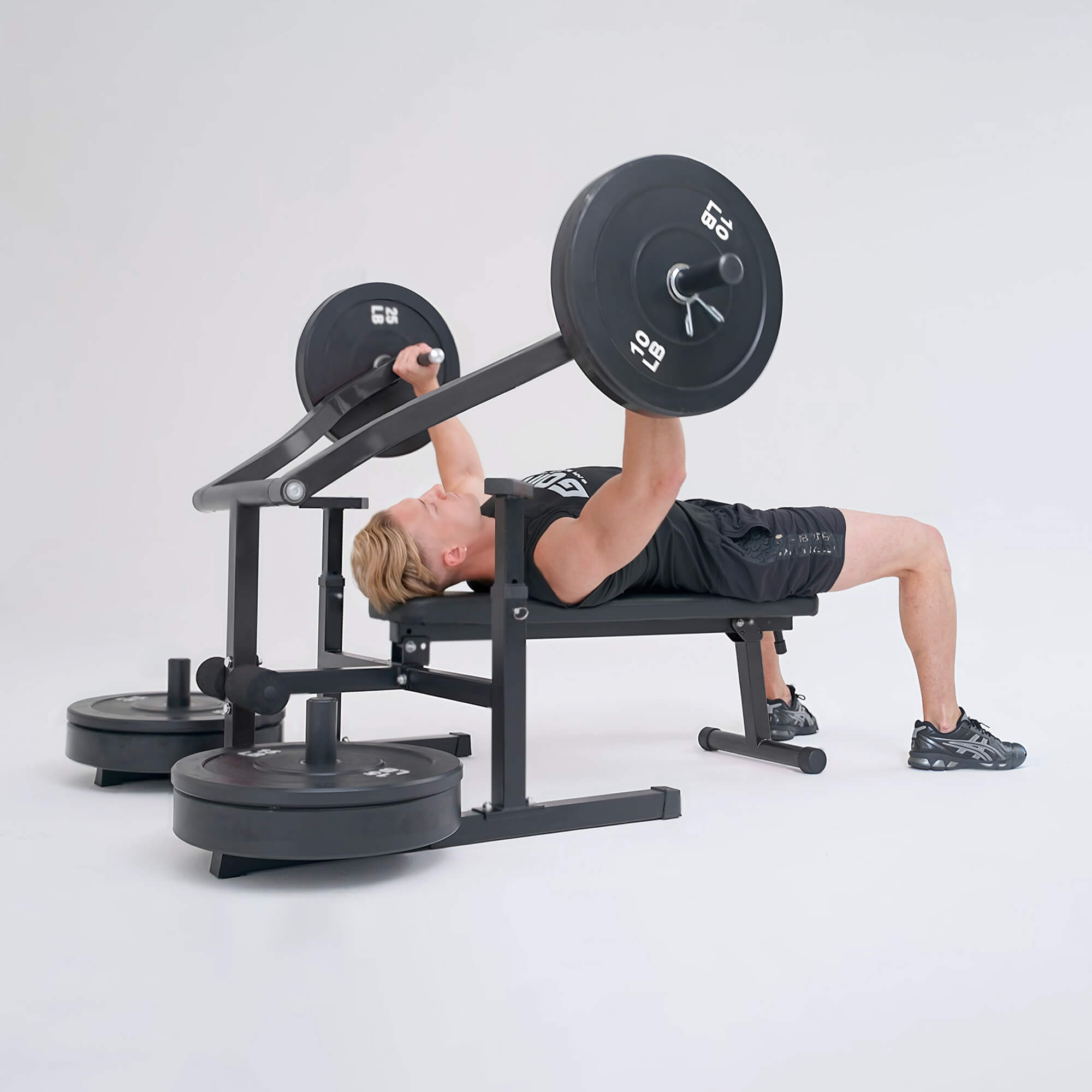 Person performing a bench press with a barbell on a weight bench against a white background.#color_black