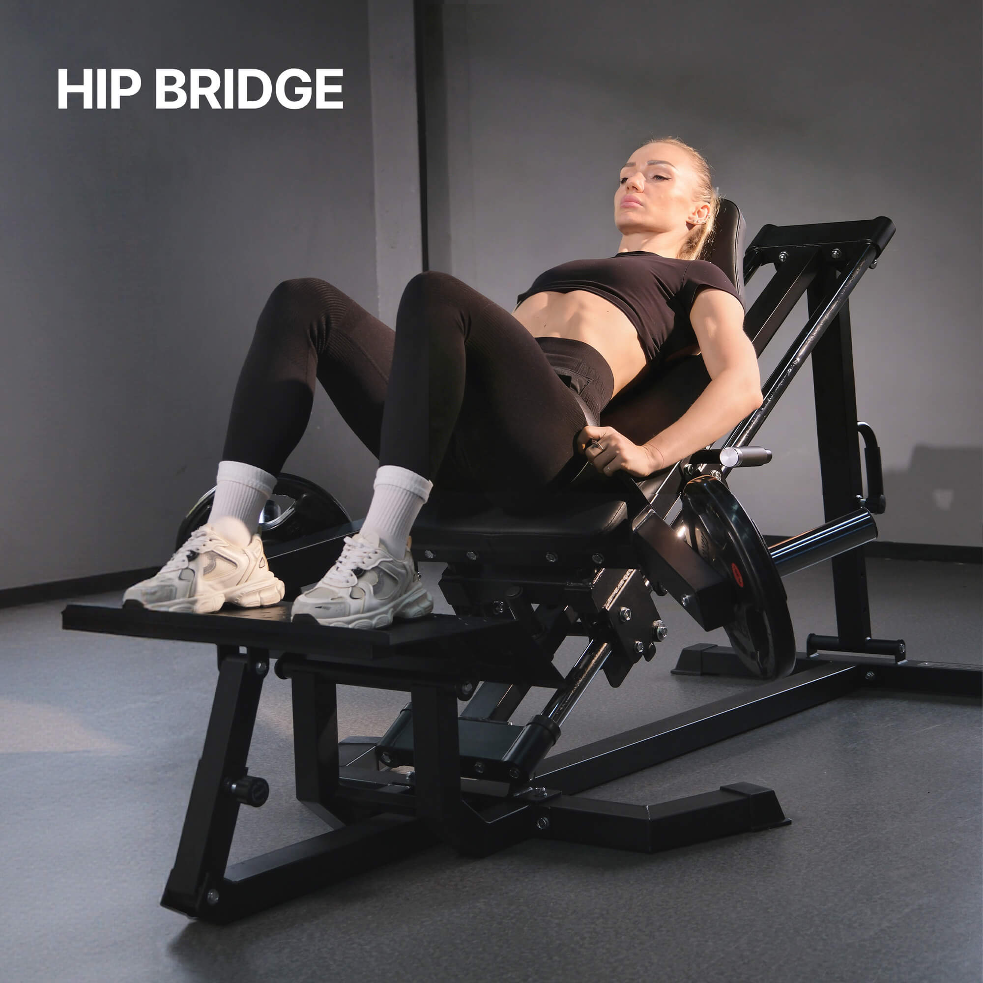 Woman exercising on a hip bridge machine with 'HIP BRIDGE' text above.