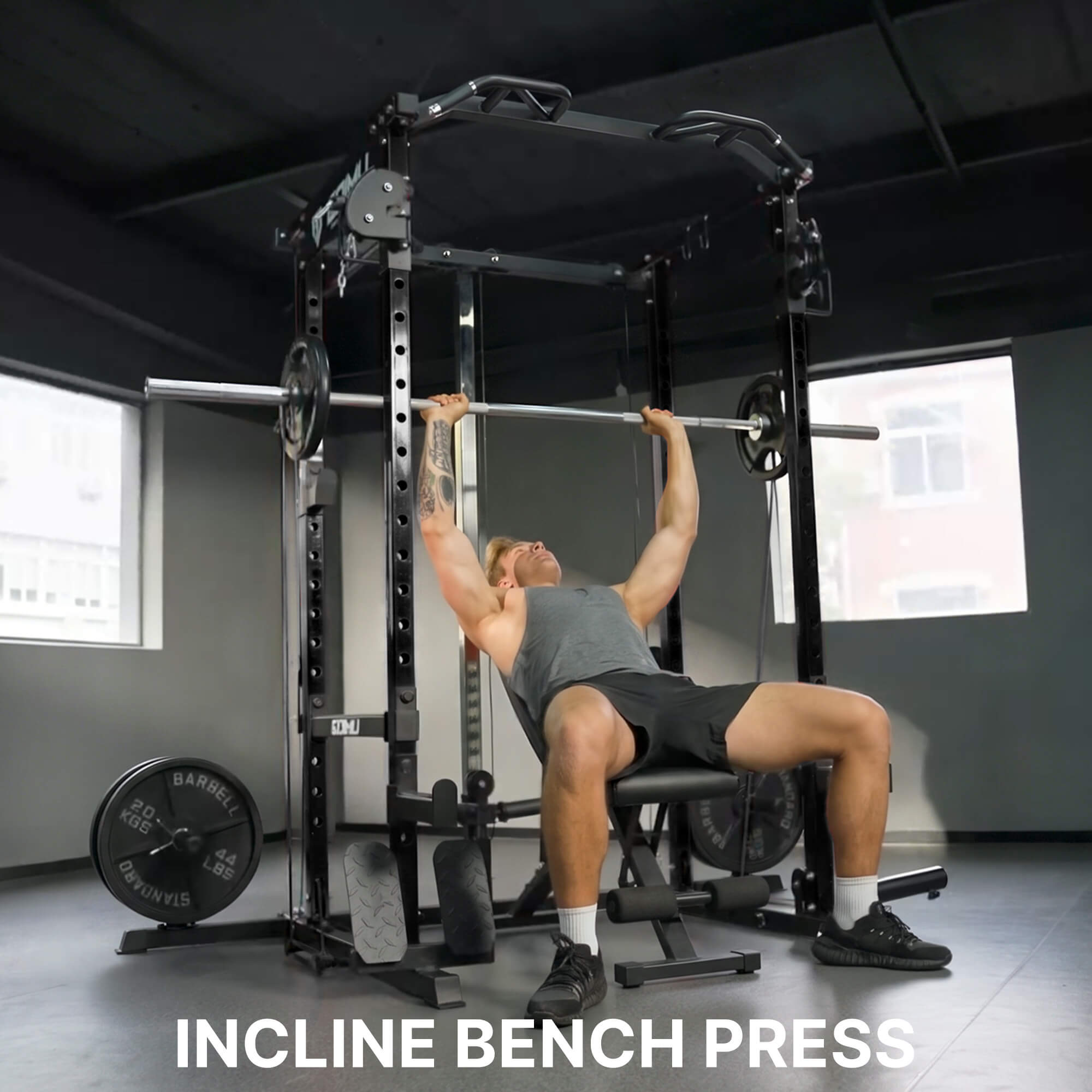 Person performing an incline bench press in a gym setting with equipment and weights visible.