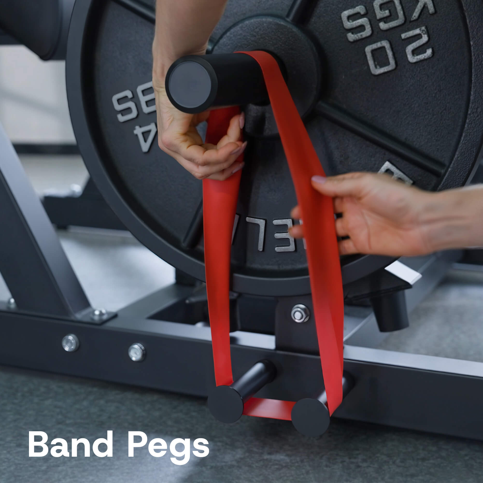 Person using red band pegs on a weight machine in a gym setting.