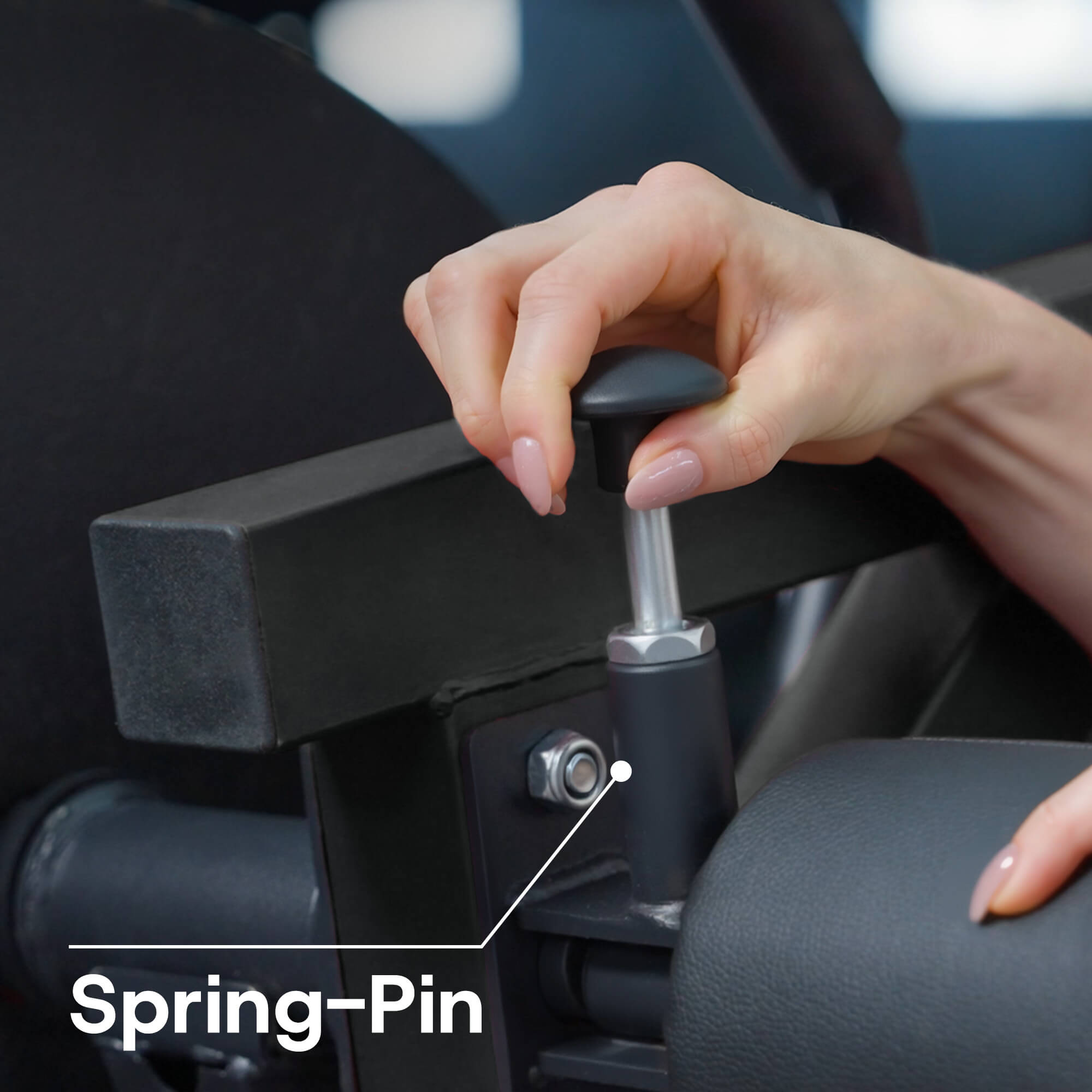 Hand adjusting a car seat with a spring pin highlighted.
