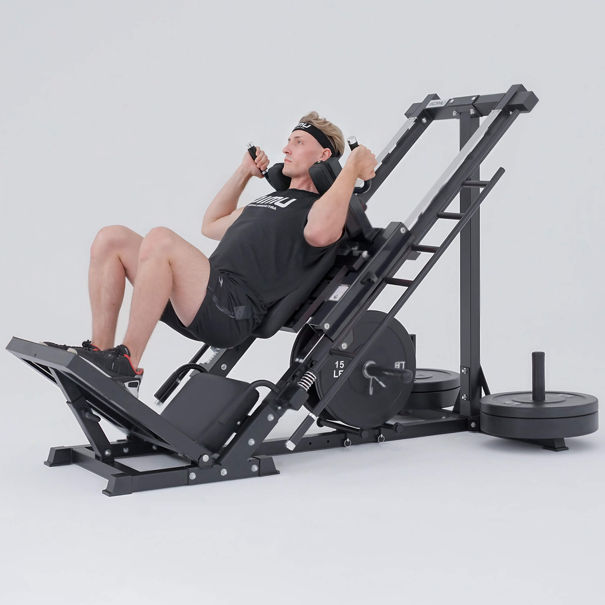 Person using a leg press machine on a white background.#color_black