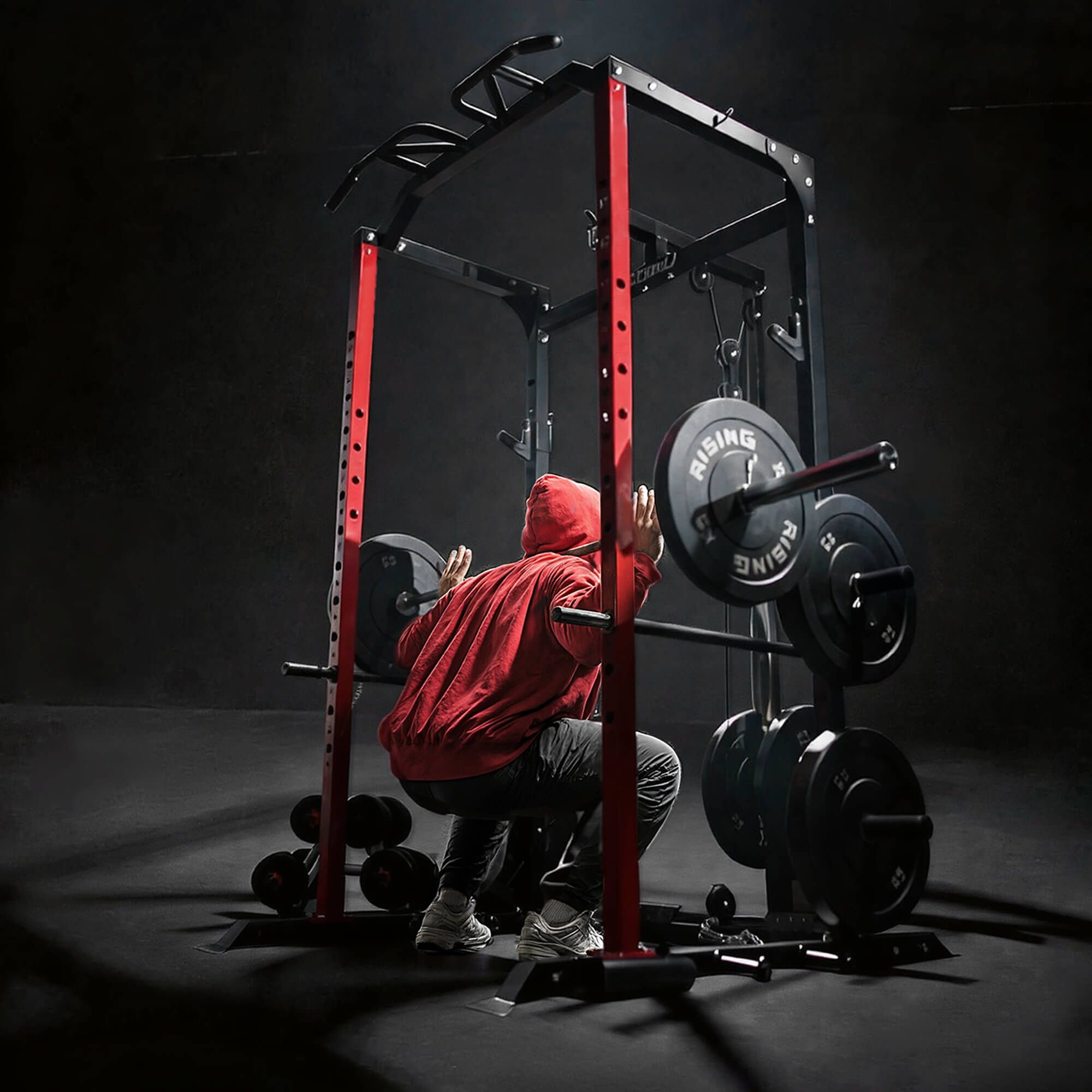Person in a red hoodie using a weight rack in a gym setting.