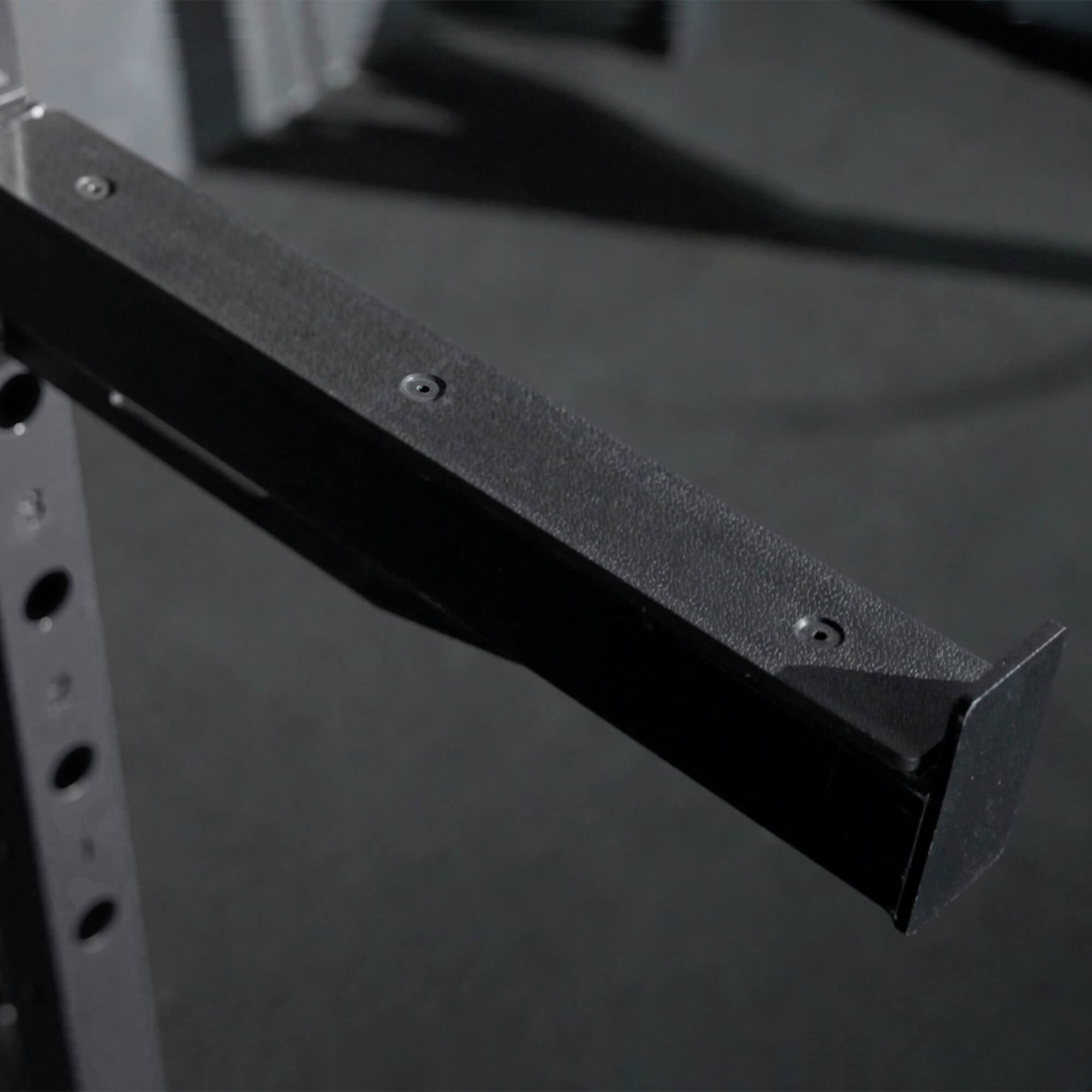 Black metal shelf bracket on a dark background.