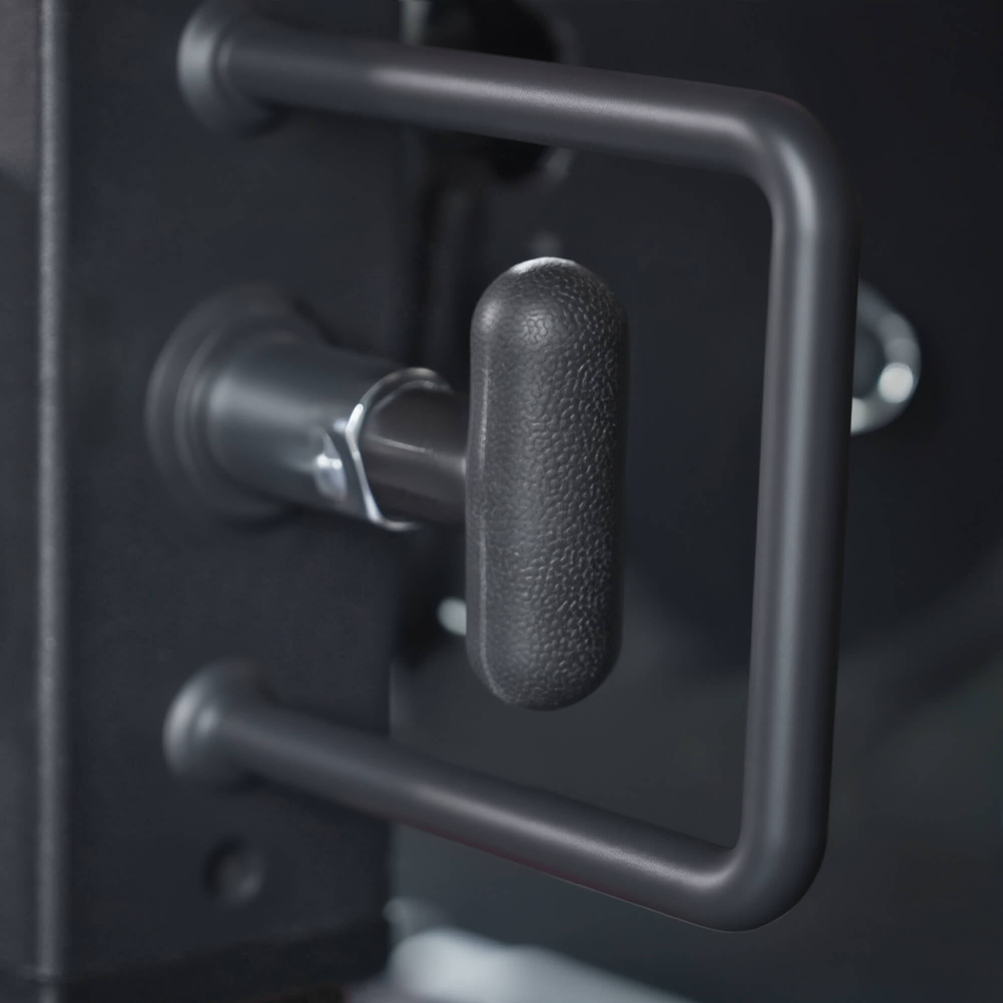 Close-up of a metallic handle on a black surface.