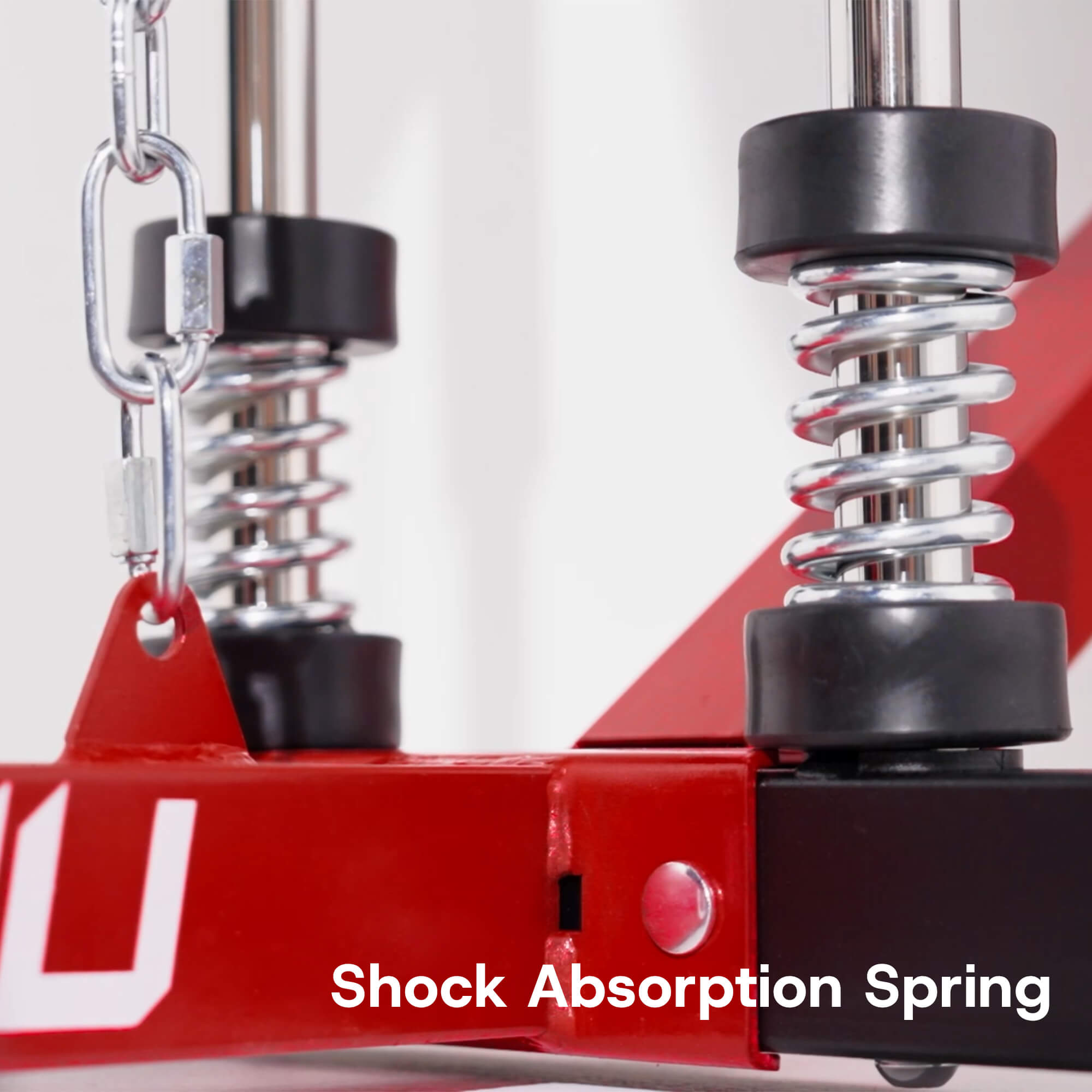 Shock absorption spring mechanism with red metal frame on a white background.