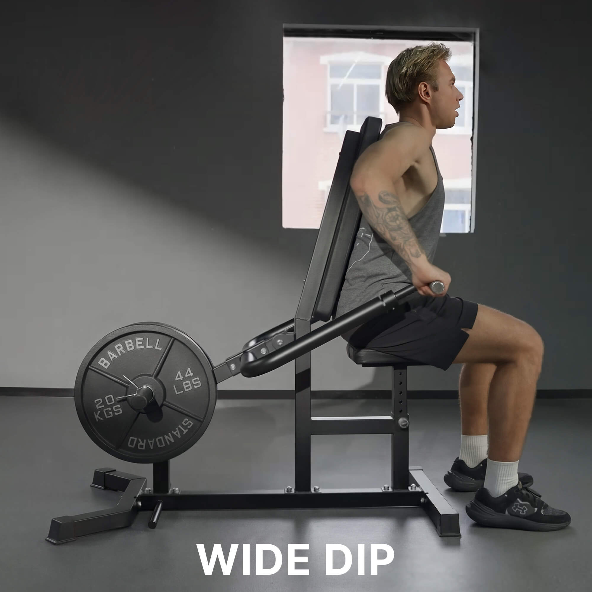 Person using a wide dip machine in a gym setting.