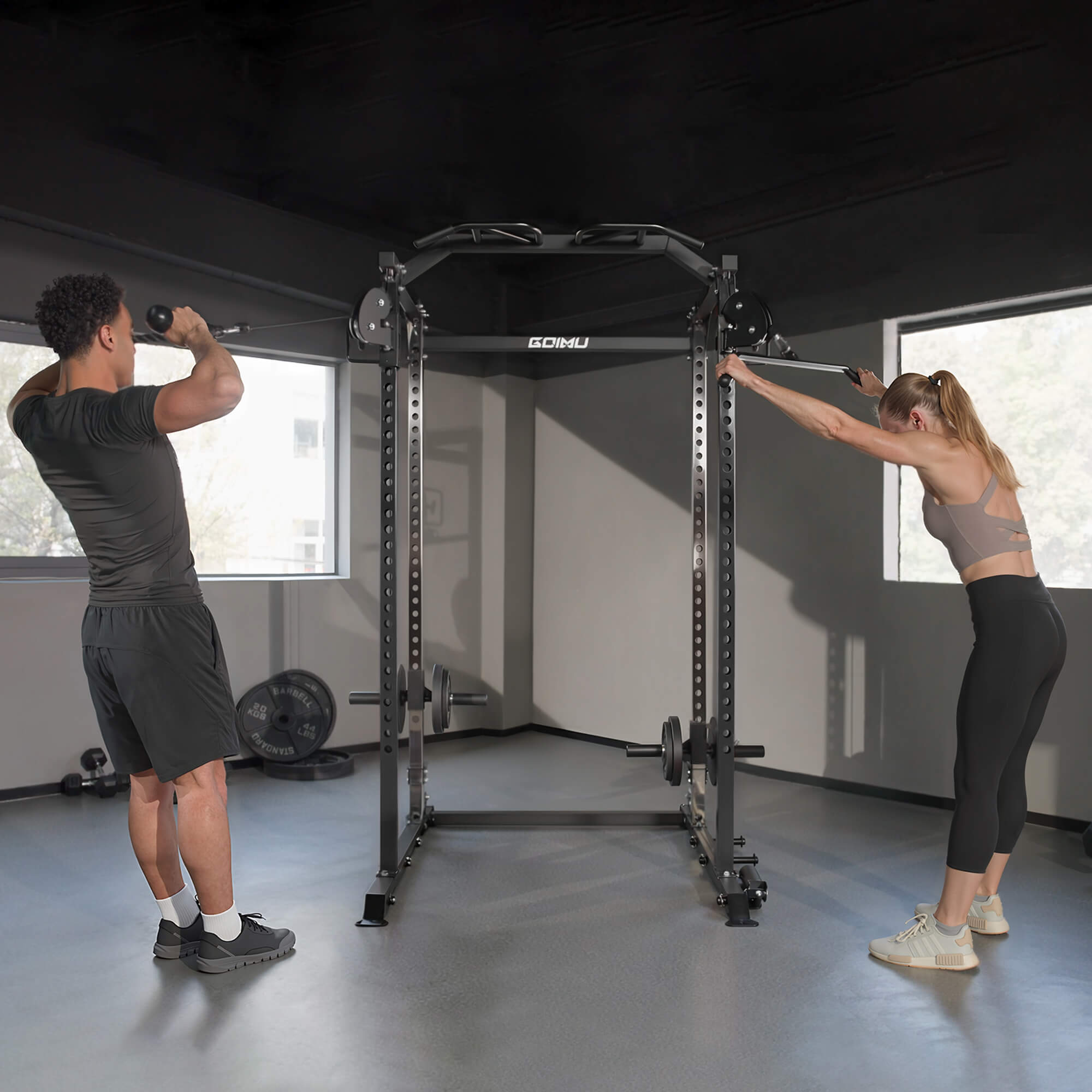 Two people setting up a power rack in a home gym.