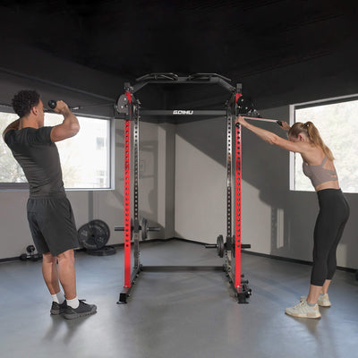 Two people using a power rack in a gym setting.