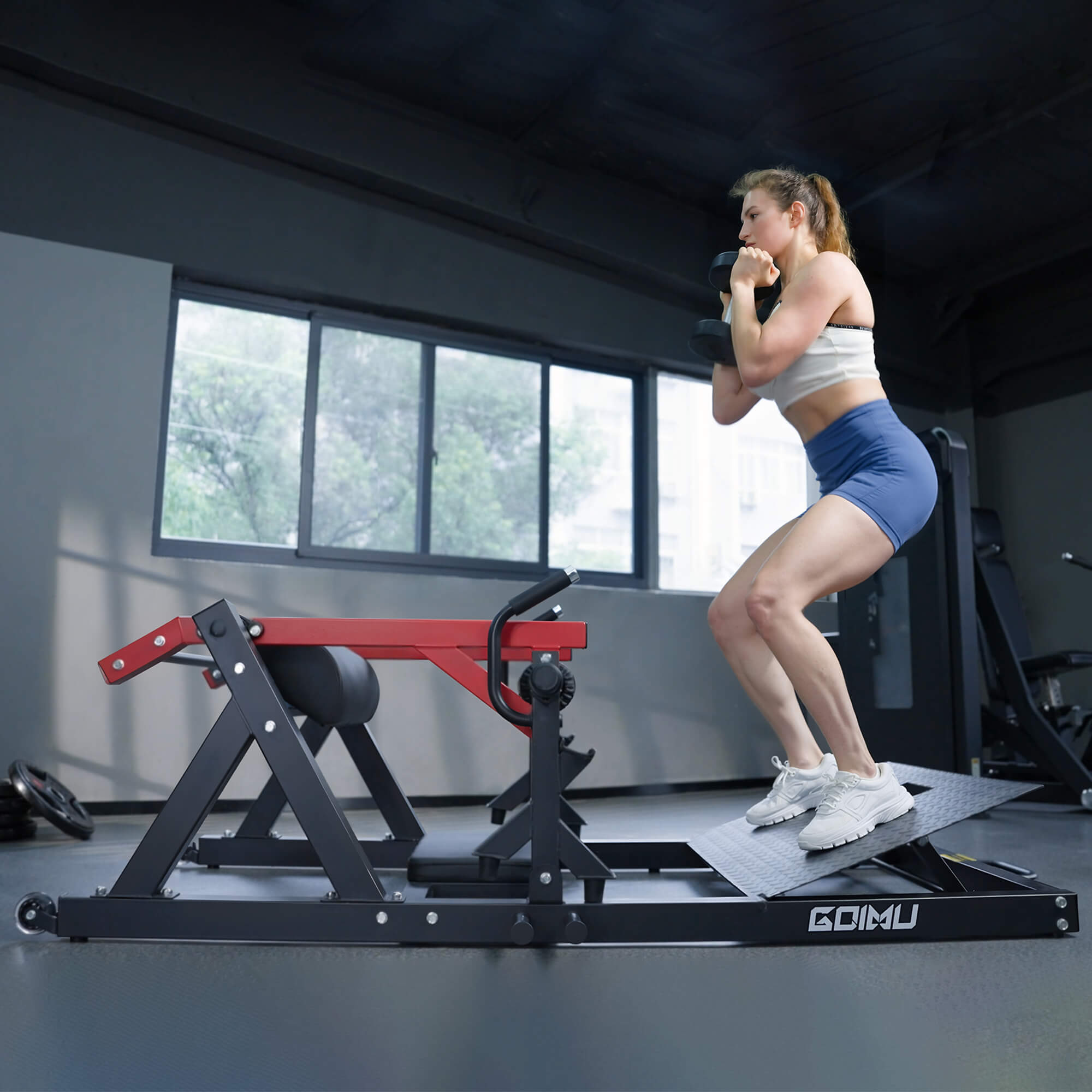 Woman exercising on a Goimu fitness machine in a gym setting.