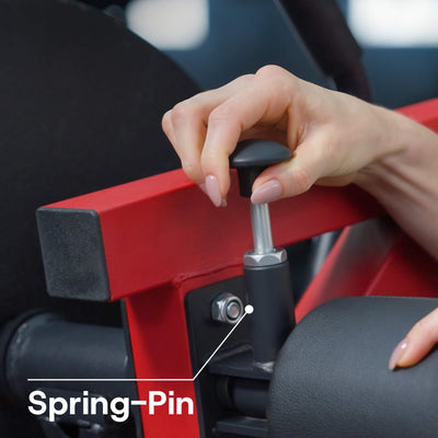 Person using a red and black tool with a spring pin labeled, against a blurred background.