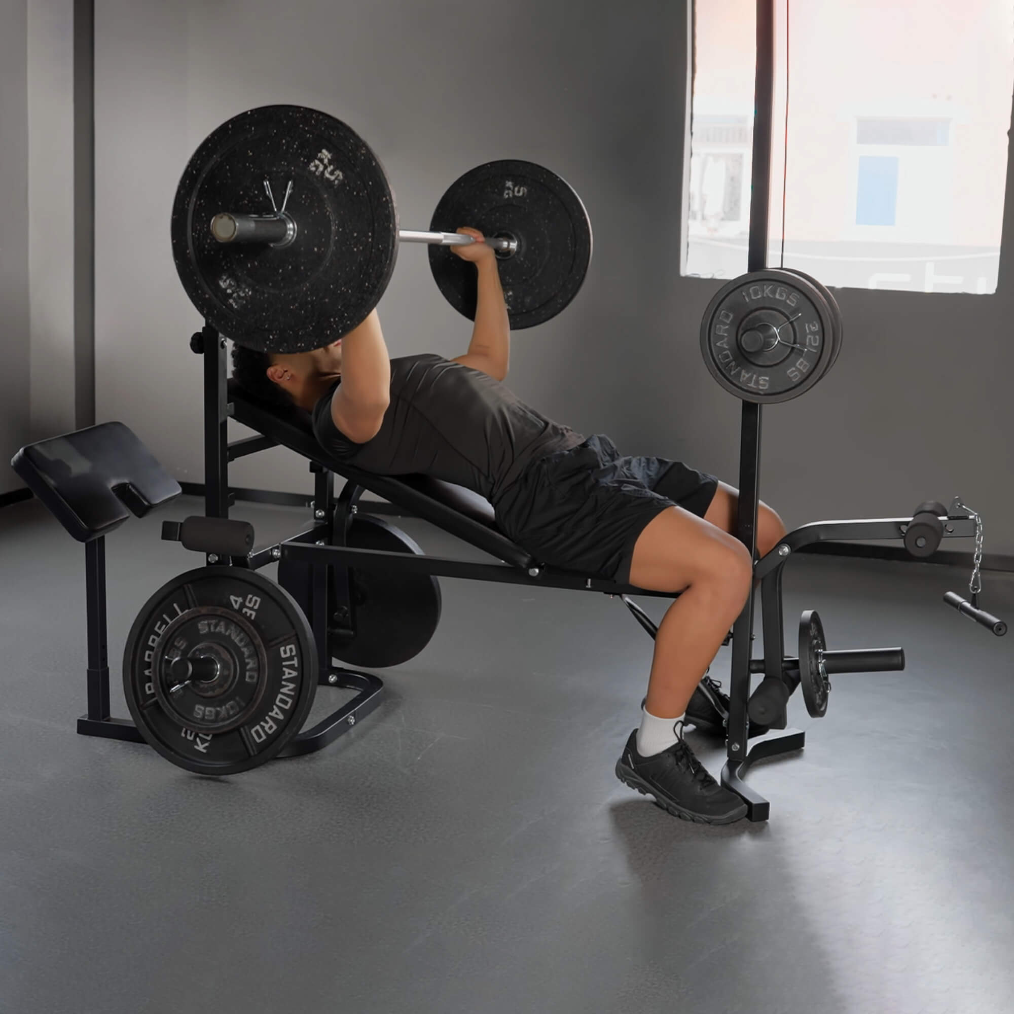 Person performing a barbell bench press in a gym setting