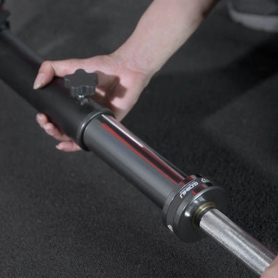Hand adjusting a metal rod with a black background.