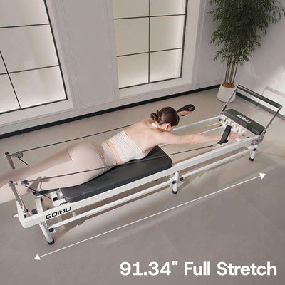Woman using a reformer machine with 'GOMU' branding in a modern room.