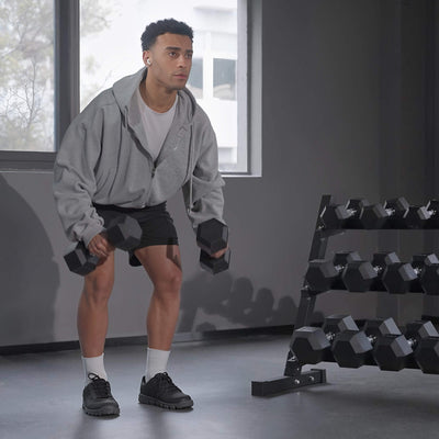 Man exercising with dumbbells in a gym setting.#pounds_360lbs-with-rack