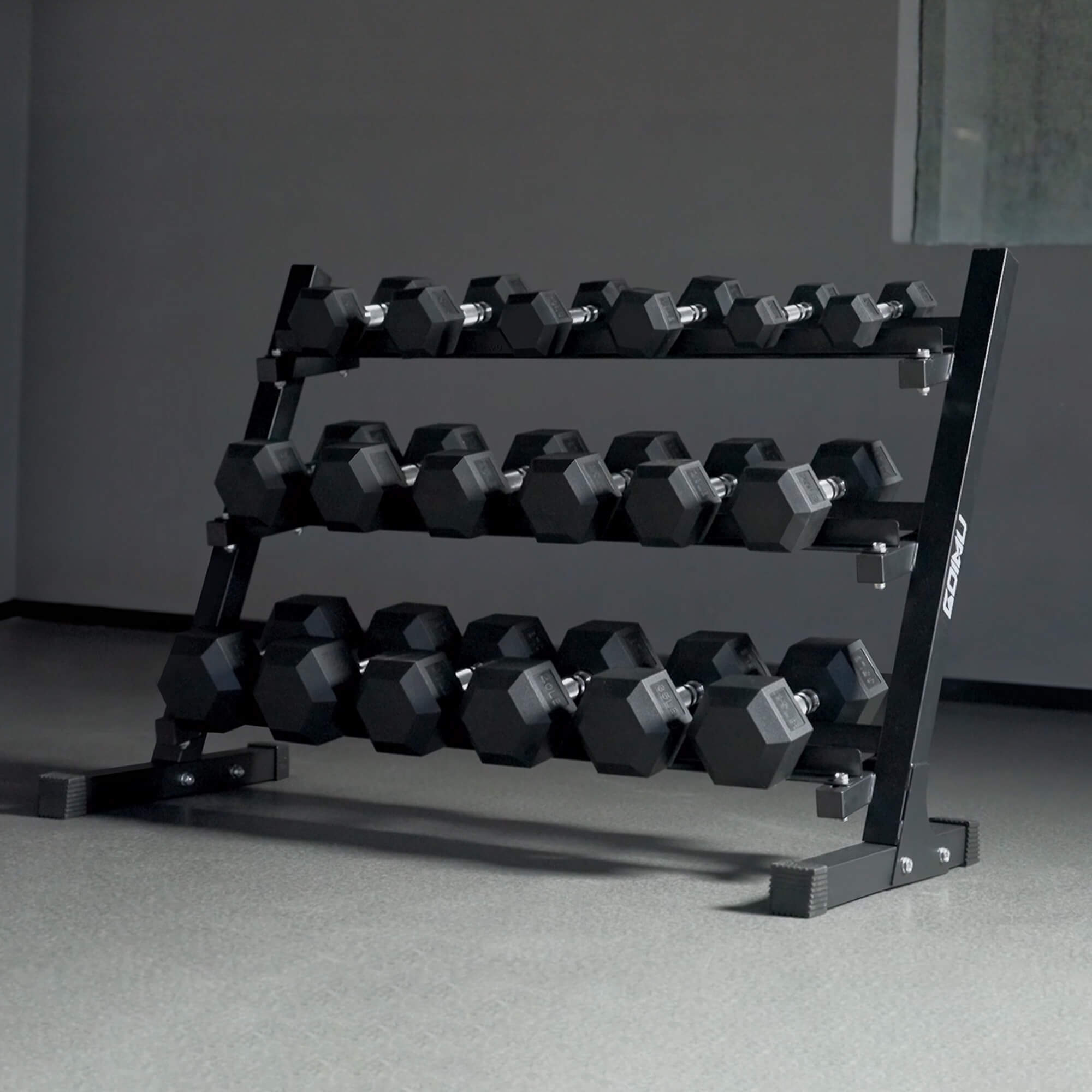 Black dumbbell rack with hexagonal dumbbells on a gray floor.#pounds_450lbs-with-rack