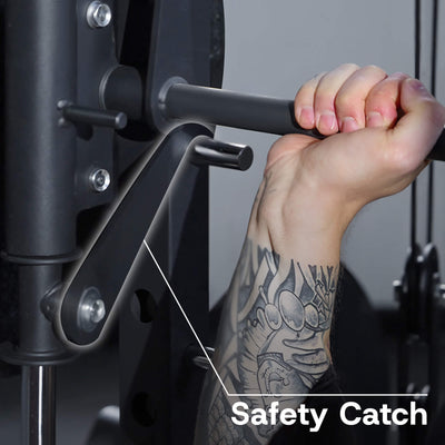 Hand holding onto a safety catch mechanism on gym equipment with a tattooed arm.