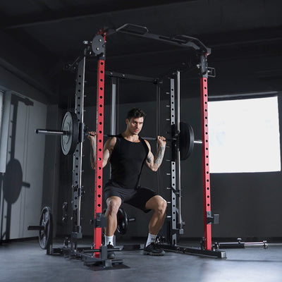 Man performing squats with a barbell in a gym setting.