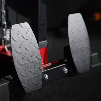 Close-up of two gray textured step pads on a vehicle's step, with a blurred background.