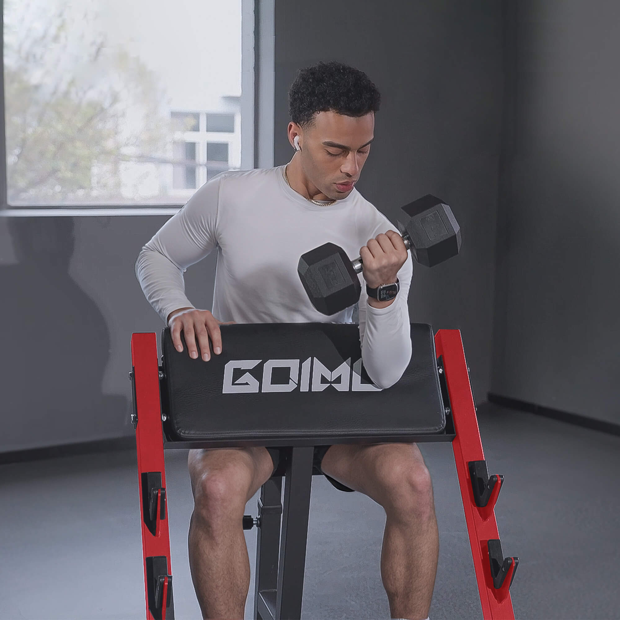 Man exercising with dumbbells on a red and black weight bench in a home setting.#color_red