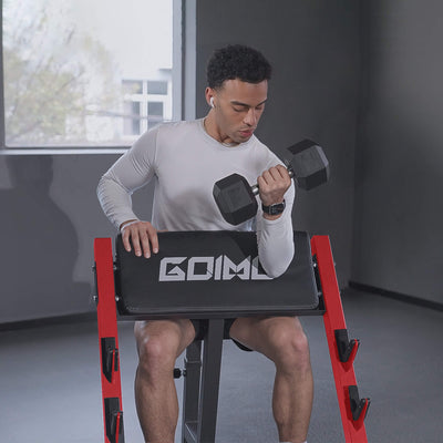 Man exercising with dumbbells on a red and black weight bench in a home setting.#color_red